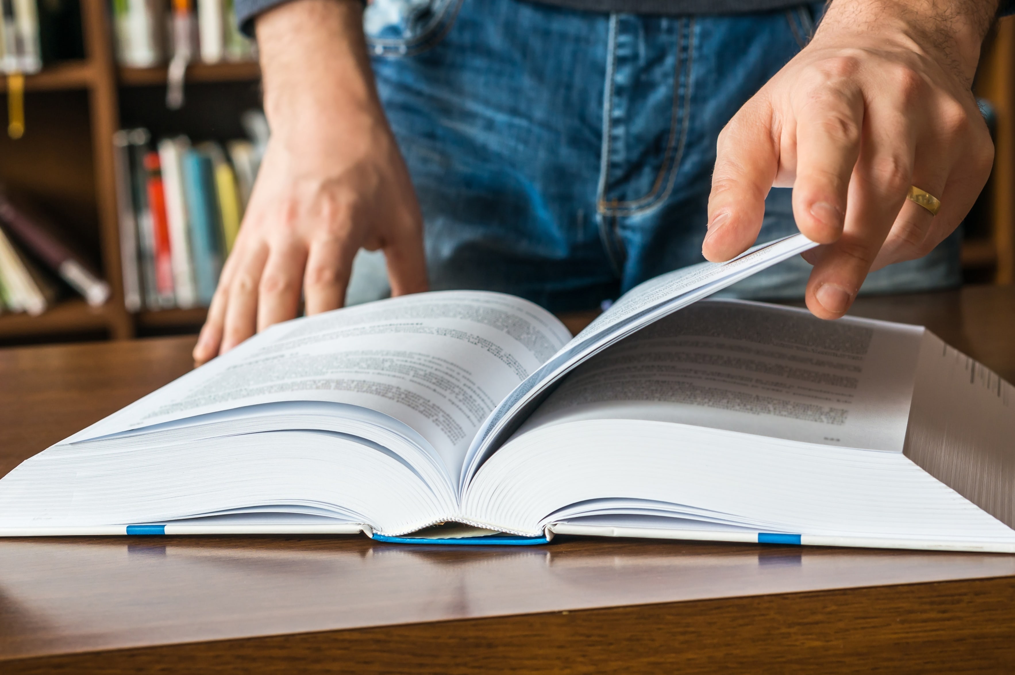 Nahaufnahme von den Händen einer Person, die in einem Buch blättert