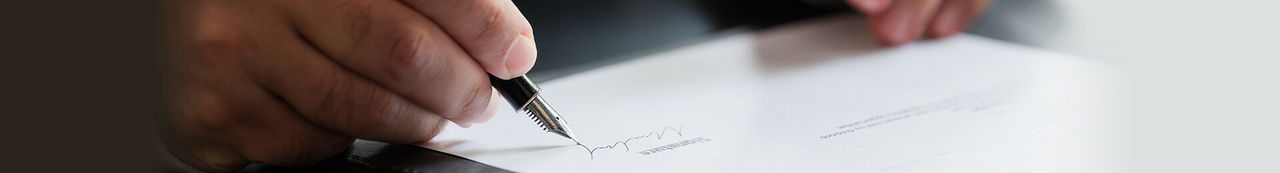 Person signing contract in an office