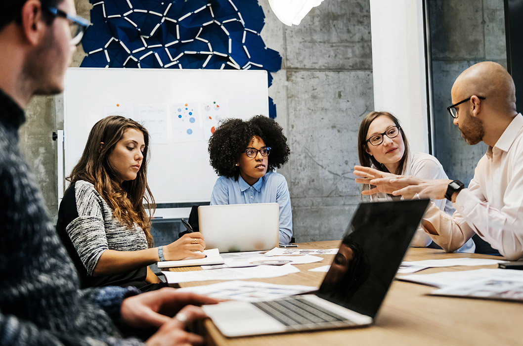 Group of people meeting in an office and sitting around a table